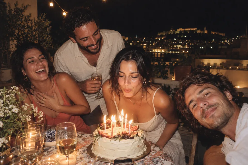 Friends celebrating with a birthday cake on a rooftop